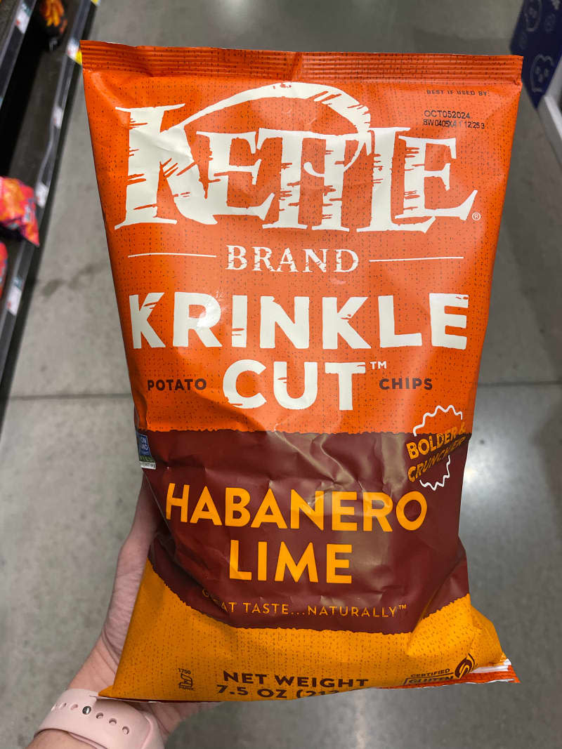 Someone holding bag of habanero lime Kettle Brand potato chips.