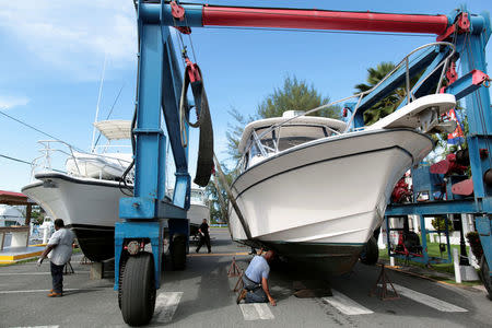 Workers put boats on dry docks in preparation, as Hurricane Irma, barreling towards the Caribbean and the southern United States, was upgraded to a Category 4 storm, in San Juan, Puerto Rico September 4, 2017. REUTERS/Alvin Baez