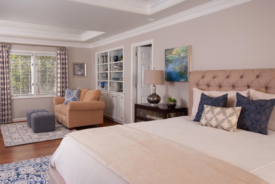 Transitional and timeless: Matching rugs by the bed and the sitting area help unite the space.