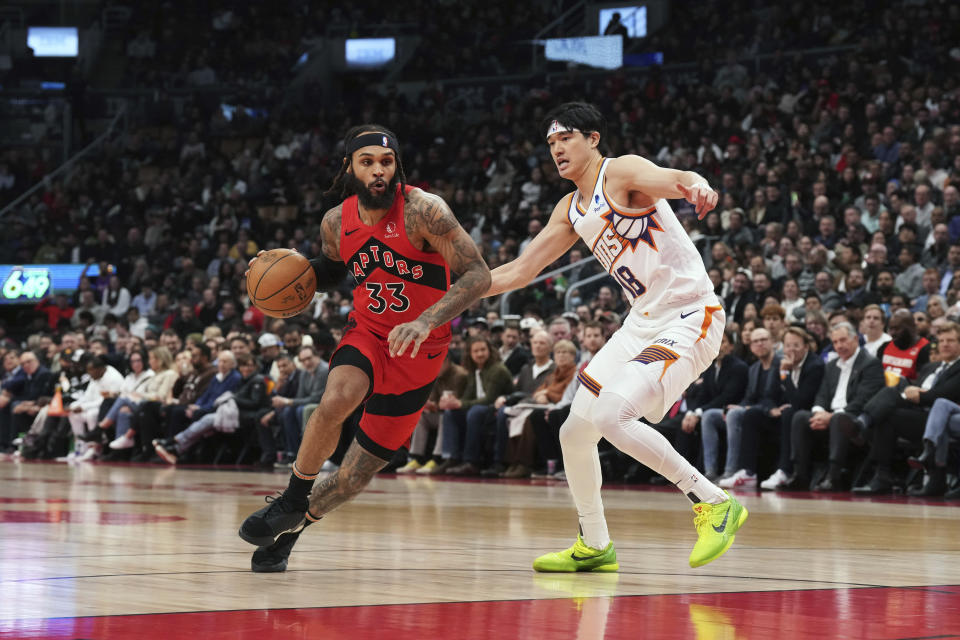 Gary Trent Jr. de los Raptors de Toronto avanza hacia la canasta superando Yuta Watanabe de los Suns de Phoenix en el encuentro de la NBA el miércoles 29 de noviembre del 2023. (Chris Young/The Canadian Press via AP)