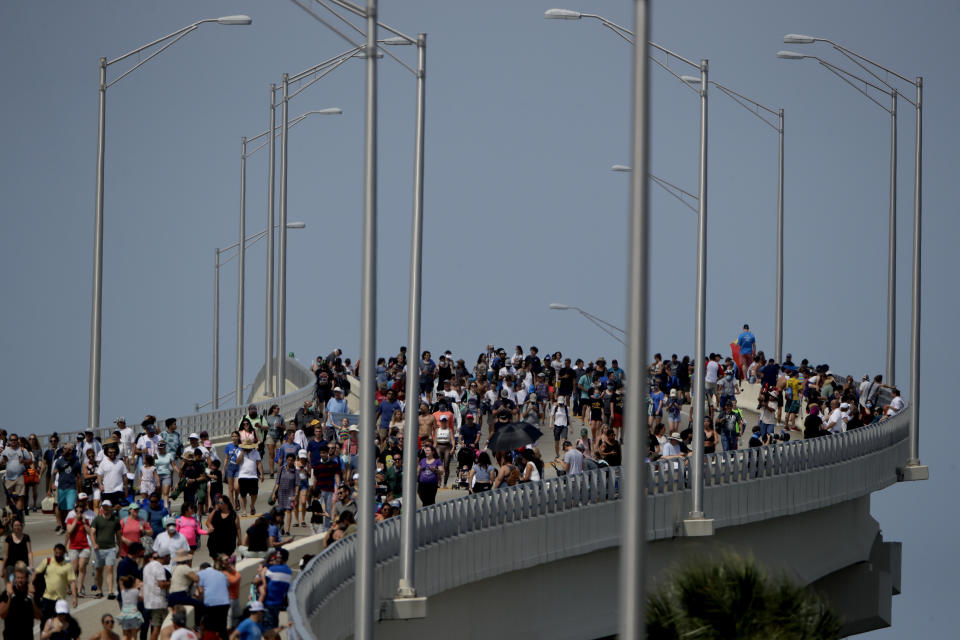 Spectators walk from their vantage point on a bridge in Titusville, Fla. after watching SpaceX Falcon 9 lift off with NASA astronauts Doug Hurley and Bob Behnken in the Dragon crew capsule, Saturday, May 30, 2020 from the Kennedy Space Center at Cape Canaveral, Fla. The two astronauts are on the SpaceX test flight to the International Space Station. For the first time in nearly a decade, astronauts blasted towards orbit aboard an American rocket from American soil, a first for a private company. (AP Photo/Charlie Riedel)