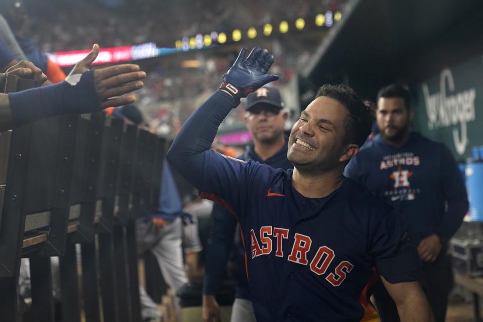 Houston Astros' Jose Altuve celebrates with teammates in the dugout after hitting a solo home run during the third inning of the team's baseball game against the Texas Rangers in Arlington, Texas, Tuesday, Aug. 30, 2022. (AP Photo/Tony Gutierrez)