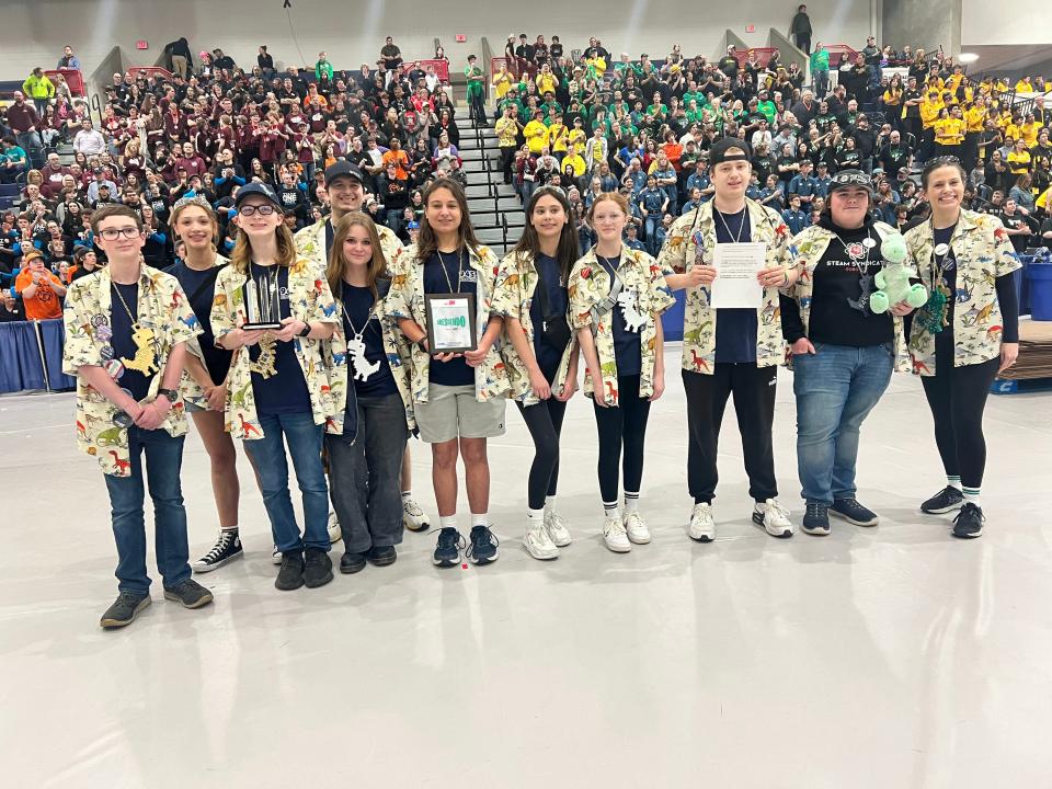 Livingston County will be represented by a high school team from the STEAM Syndicate at the FRC World Championships this week in Houston. From left: Aiden Gorang, Alaina Reynolds, Carter Leestma, Coach Brent Leestma (background), Elizabeth Arrowood (foreground), Joey Linton, Libby Linton, Keira Chapel, Logan Chapel, Brendan Bertan, Coach Becky Linton (not pictured - Charlie Moore, Nick Ray). The DinoMights accept the Rookie All-Star Award at the Michigan State Championship.