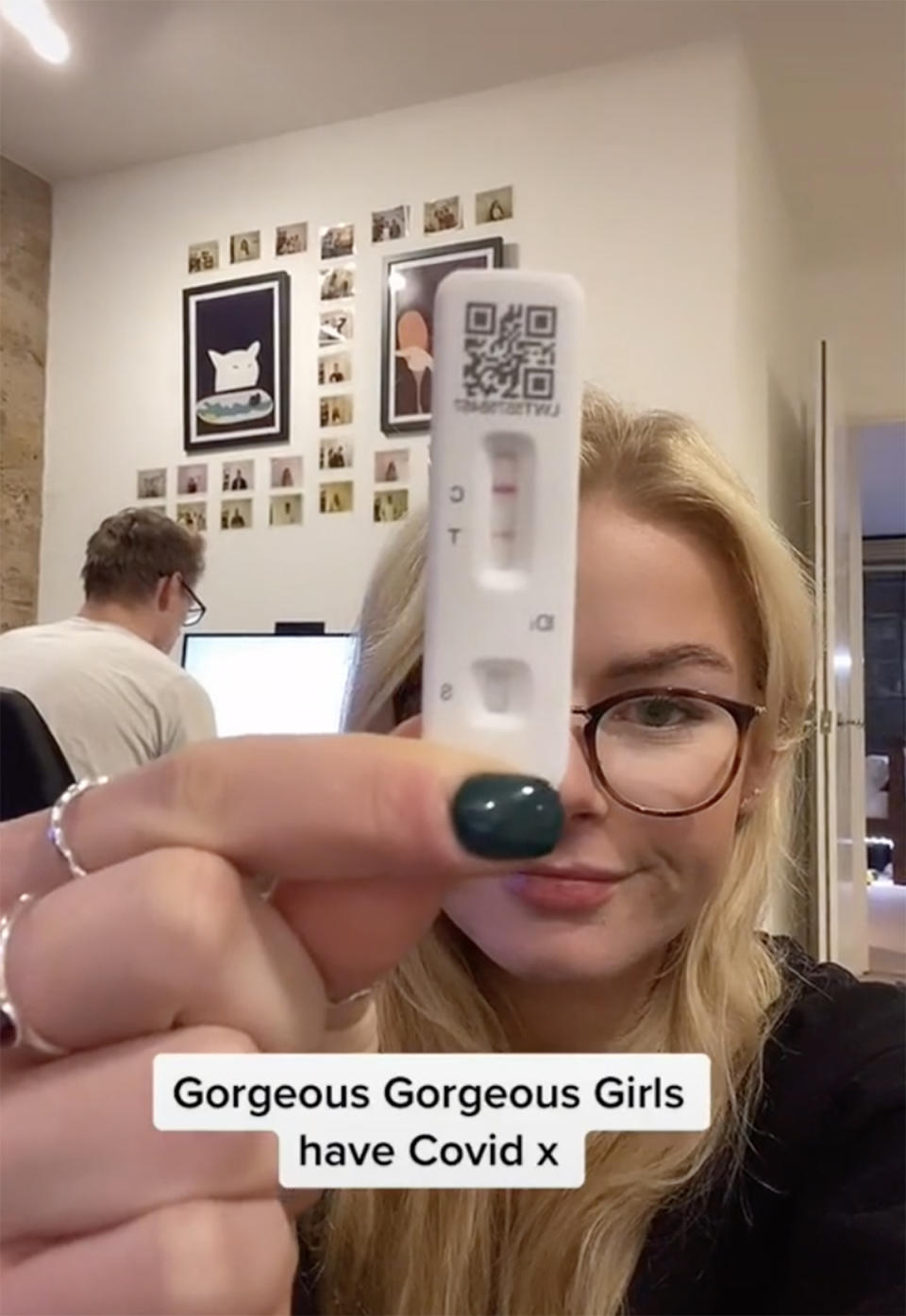 A blonde young woman holding up a positive Covid rapid test to the camera. Photo: TikTok/flatiekight.