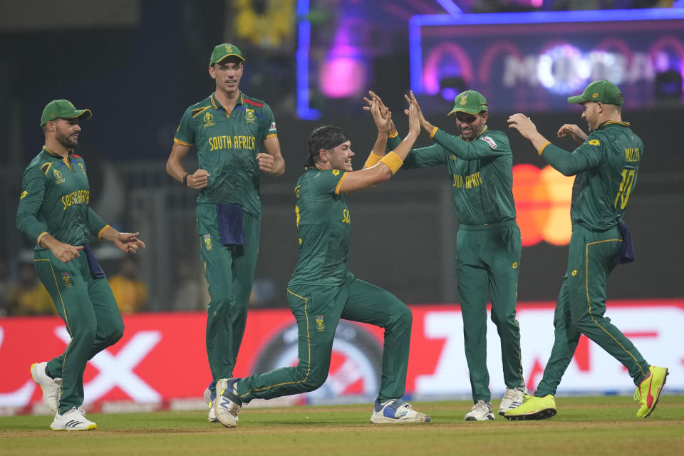 South Africa's Gerald Coetzee, center, celebrates with teammates after the dismissal of England's Harry Brook during the ICC Men's Cricket World Cup match between South Africa and England in Mumbai, India, Saturday, Oct. 21, 2023. (AP Photo/ Rafiq Maqbool)