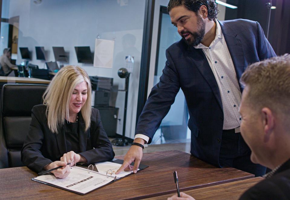 Jen Stillwagon, left and Simon Thomas, CEO of DOBI Real Estate, go over paperwork at their offices.