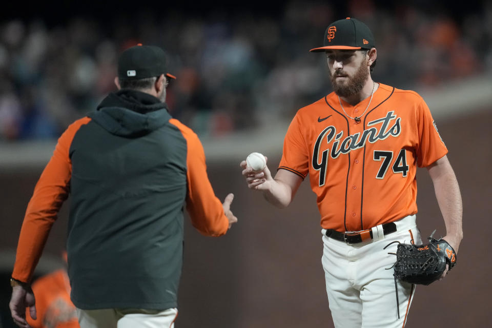 San Francisco Giants manager Gabe Kapler, left, takes the ball from pitcher Ryan Walker during the seventh inning of the team's baseball game against the Chicago Cubs in San Francisco, Friday, June 9, 2023. (AP Photo/Jeff Chiu)