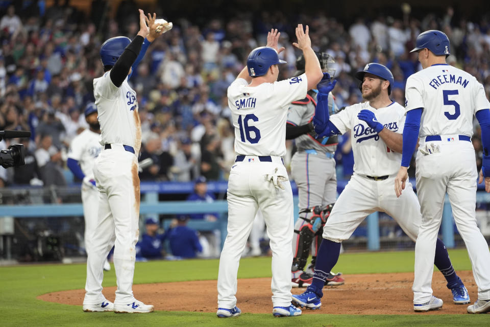 Los Angeles Dodgers' Max Muncy, second from right, celebrates his grand slam with teammates at home plate, during the first inning of the team's baseball game against the Miami Marlins, Tuesday, May 7, 2024, in Los Angeles. (AP Photo/Marcio Jose Sanchez)