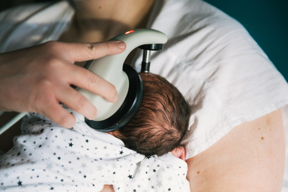 Close-up of a baby's head being checked with a medical device by a healthcare professional