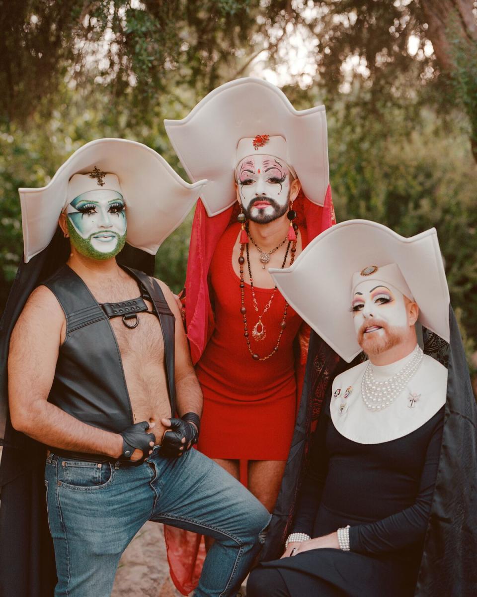 Three drag nuns in wimpoles outdoors.