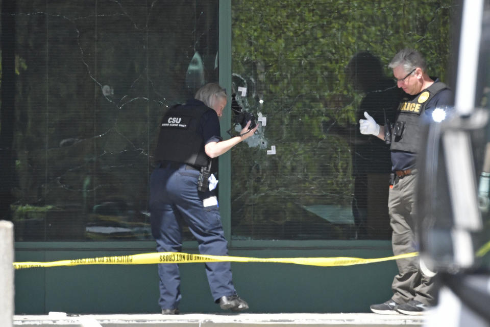 FILE - A Louisville Metro Police technician photographs bullet holes in the front glass of the Old National Bank building in Louisville, Ky., Monday, April 10, 2023. A shooting at the bank killed and wounded several people police said. The suspected shooter was also dead. The U.S. is setting a record pace for mass killings in 2023, replaying the horror in a deadly loop roughly once a week so far this year. The bloodshed overall represents just a fraction of the deadly violence that occurs in the U.S. annually. (AP Photo/Timothy D. Easley, File)