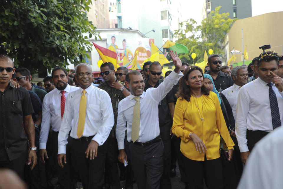 Maldives’ former president Mohamed Nasheed, center, waves to the public in Male, Maldives, Thursday, Nov.1, 2018. Nasheed, the first democratically elected president of the Maldives returned home Thursday after more than two years in exile to escape a long prison term. President elect Ibrahim Mohamed Solih is on his right. (AP Photo/Mohamed Sharuhaan)