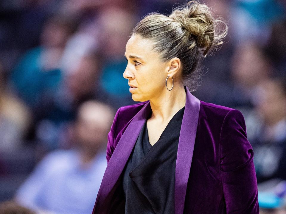 Becky Hammon stands courtside at an NBA game.