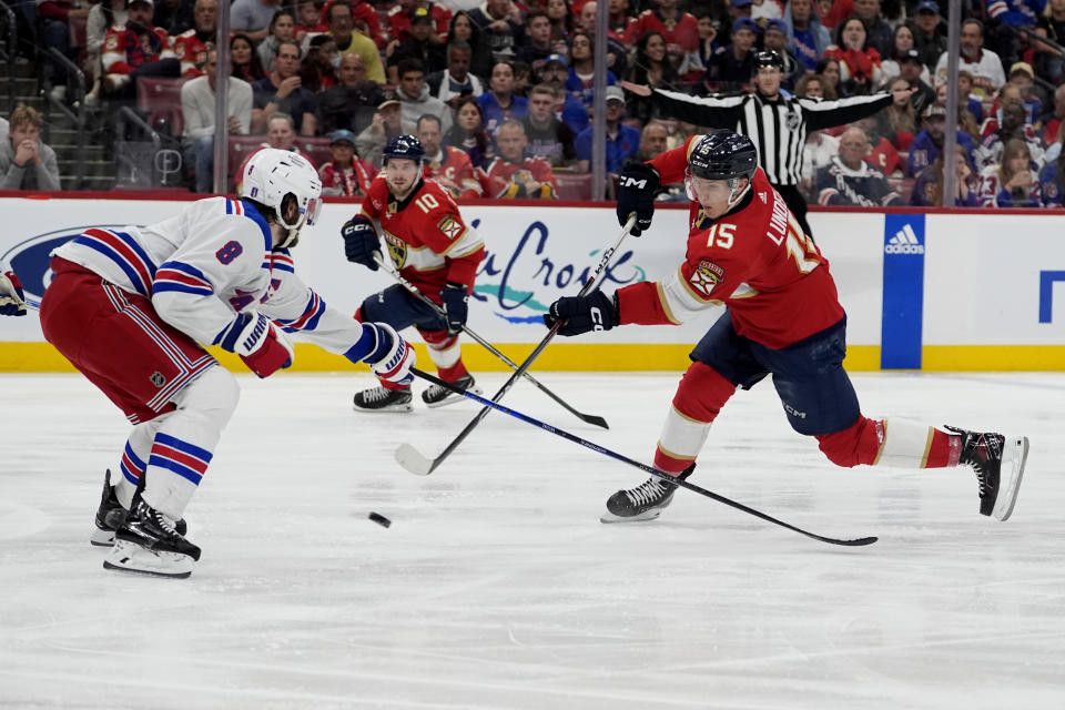 Florida Panthers center Anton Lundell (15) shoots as New York Rangers defenseman Jacob Trouba (8) defends during the second period of Game 6 in the Eastern Conference finals of the NHL hockey Stanley Cup playoffs Saturday, June 1, 2024, in Sunrise, Fla. (AP Photo/Lynne Sladky)