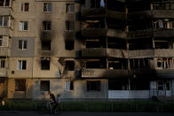 A man rides a bicycle past a building destroyed in Russian attacks in Borodyanka, on the outskirts of Kyiv, Ukraine, Sunday, June 12, 2022. (AP Photo/Natacha Pisarenko)