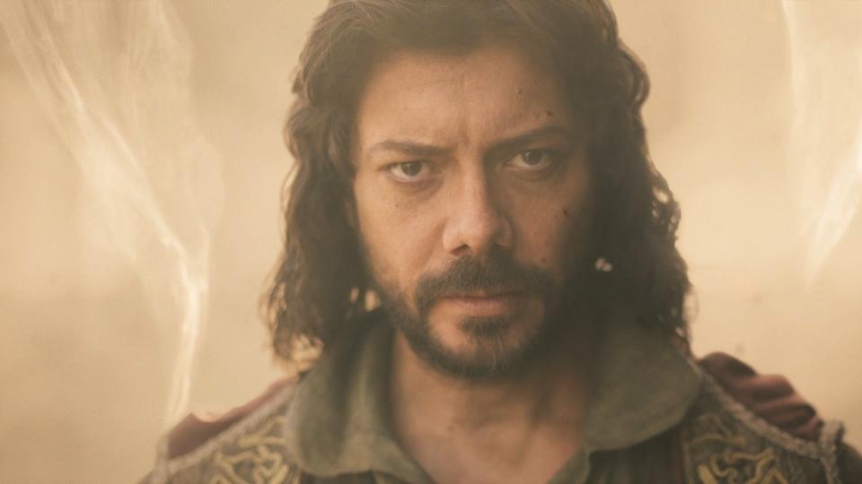 A close-up shot of Logain Ablar (Alvaro Morte) in battle – he has shoulder-length black hair, piercing black eyes, and a beard. Weaves of air surround him from behind