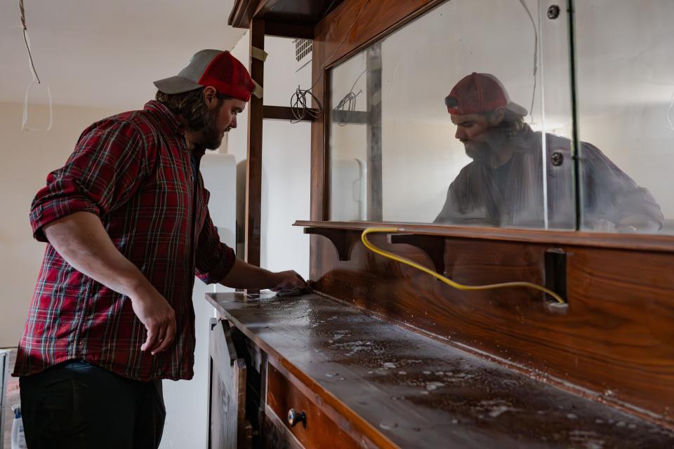 Austin Hill wipes down the bar in the possible basement speakeasy room of 1231 W. Mountain Ave. in Fort Collins on Monday. Austin and his brother, Ryan Hill, purchased the century-old home last year and were wrapping up its renovation this month.
