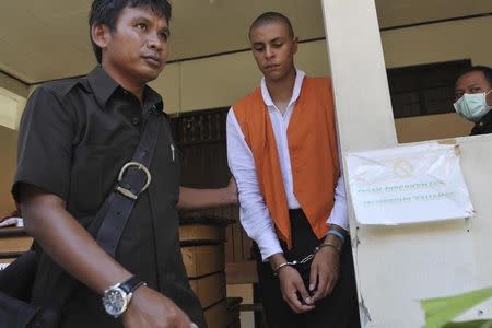 U.S. citizen Tommy Schaefer (C), 21, is escorted by plain clothes policemen as he walks to his trial in Denpasar court on the Indonesian resort island of Bali January 21, 2015 in this picture taken by Antara Foto. REUTERS/Nyoman Budhiana/Antara Foto