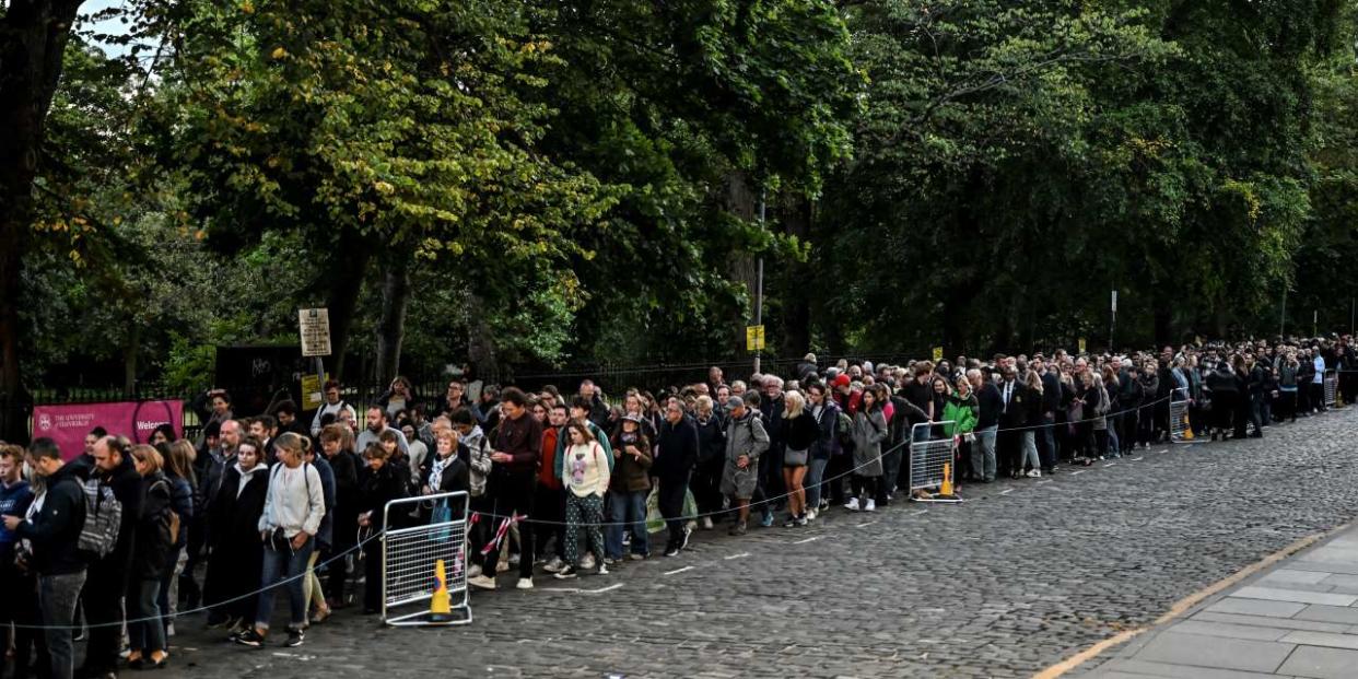 Members of the public queue in George Square Gardens to pay their respects before the coffin of Queen Elizabeth II lying at rest in Giles' Cathedral, in Edinburgh, on September 12, 2022. - Mourners will on September 12, 2022 get the first opportunity to pay respects before the coffin of Queen Elizabeth II, as it lies in an Edinburgh cathedral where King Charles III will preside over a vigil. (Photo by Louisa Gouliamaki / AFP)