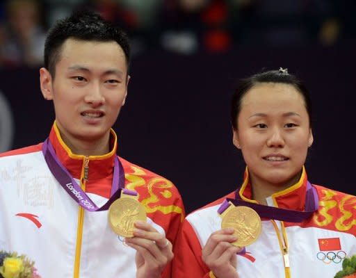 China's Zhang Nan (L) and Zhao Yunlei pose with their gold medals after wining the badminton mixed doubles at the London 2012 Olympic Games. China won the opening badminton title of the London Games as Zhang and Zhao became the first boyfriend and girlfriend duo to win Olympic gold medals together