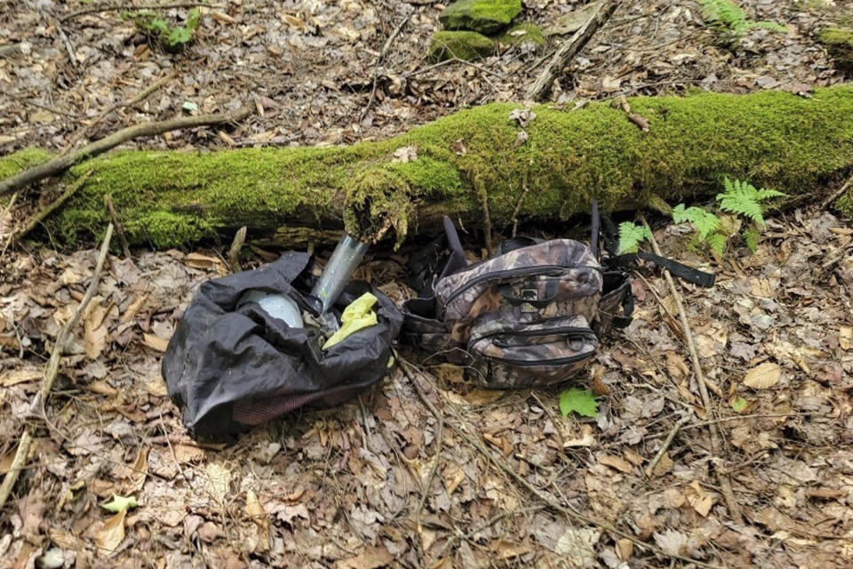 In this image provided by the Pennsylvania State Police, two bags of supplies, authorities believe belong to an escaped inmate, were found by law enforcement while searching in the woods in northwestern Pennsylvania. The date and location were not disclosed due to the ongoing investigation. Michael Burham, 34, fled the Warren County Prison late Thursday, July 5, 2023. by climbing on exercise equipment to gain access to the roof and then used a rope fashioned from jail bedding to get down, authorities said. Prior to his escape, Burham had been held on $1 million bail and was facing numerous charges, including kidnapping and burglary. (Pennsylvania State Police via AP)