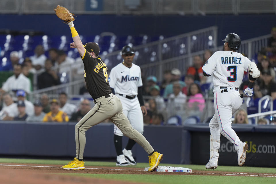 San Diego Padres first baseman Jake Cronenworth (9) puts out Miami Marlins' Luis Arraez (3) at first during the first inning of a baseball game, Tuesday, May 30, 2023, in Miami. (AP Photo/Wilfredo Lee)