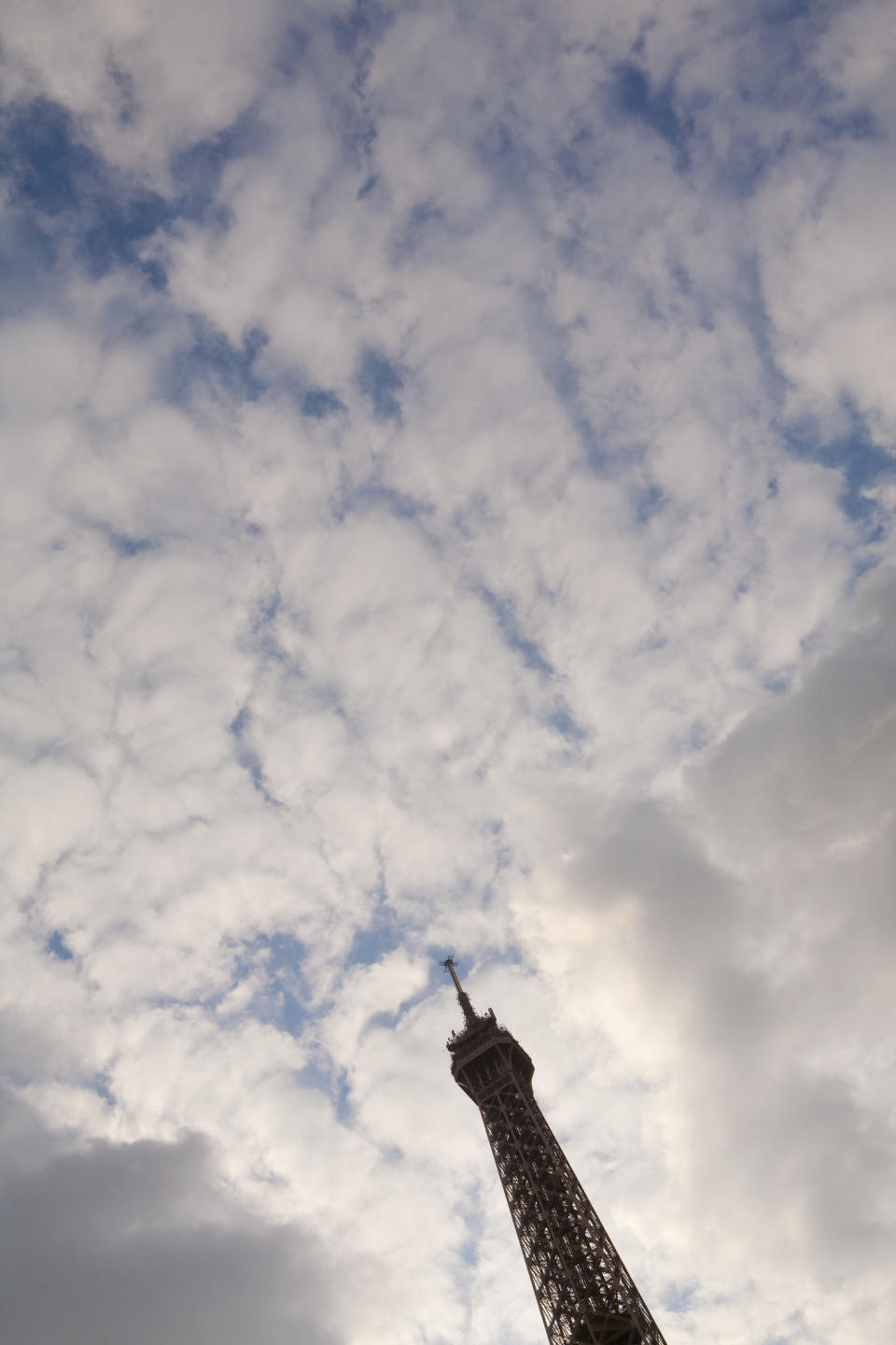 Eiffel Tower against a cloudy sky, viewed from below