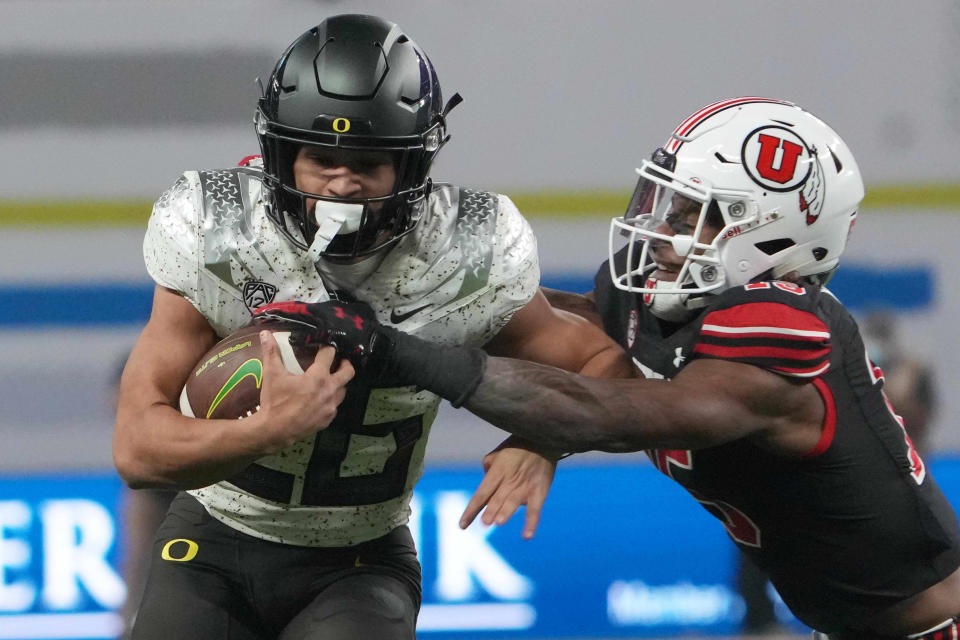 Oregon's Travis Dye (26) tries to get past Utah cornerback Malone Mataele during the first half of Friday's game. Dye was the game's leading rusher with 82 yards.