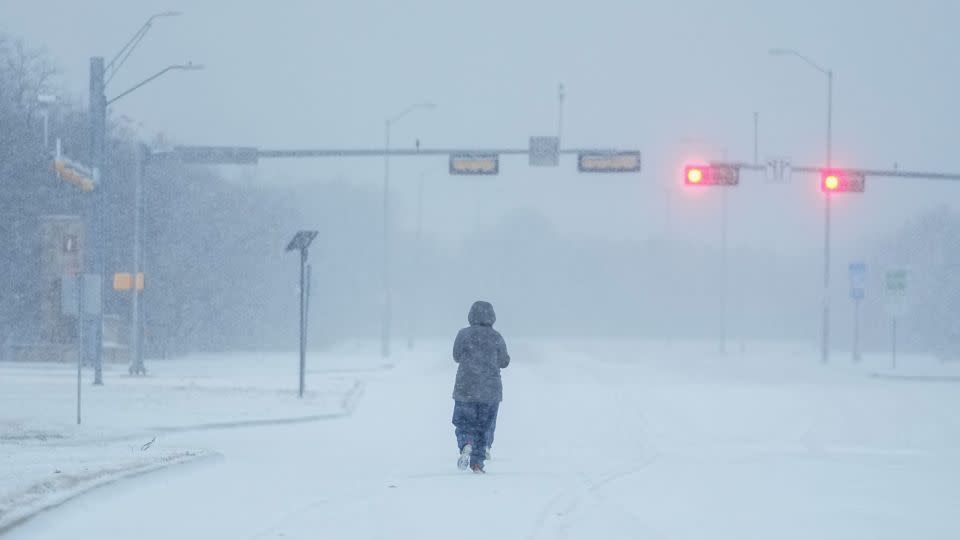 A jogger trots on a snow-covered road during a winter storm, Monday, Jan. 15, 2024, in Grand Prairie, Texas. - Julio Cortez/AP