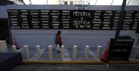 Pedestrians walk by a sign that reads "Memory and Justice" next to the names of the victims of the 1994 Amia bombing, placed outside the AMIA Jewish community center before a demonstration to demand justice over the death of Argentine prosecutor Alberto Nisman in Buenos Aires January 21, 2015. REUTERS/Marcos Brindicci