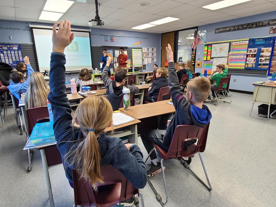 Isaac Hertenstein and a fellow classmate from Greencastle High School help teach personal finance lessons to a class of fifth graders at Tzouanakis Elementary School in Greencastle,IN as part of their work with the non profit group "Students Teaching Finance" which aims to help teach personal finance skills and concepts to K-8 students, on Nov. 18, 2022.