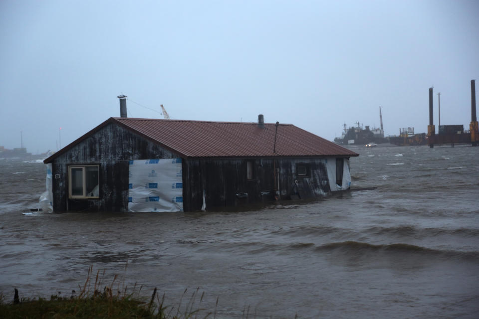 A home is seen floating in the Snake River near Nome, Alaska, on Saturday, Sept. 17, 2022. Much of Alaska's western coast could see flooding and high winds as the remnants of Typhoon Merbok moved into the Bering Sea region. The National Weather Service says some locations could experience the worst coastal flooding in 50 years. (AP Photo/Peggy Fagerstrom)