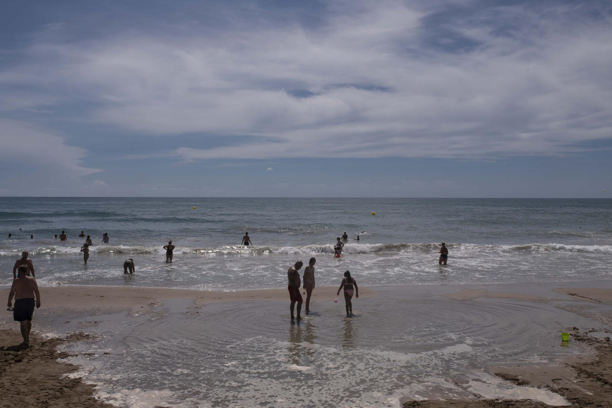 Visitantes en Sant Sebastià, una popular playa familiar en Sitges, España, en agosto de 2022. (María Contreras Coll/The New York Times).
