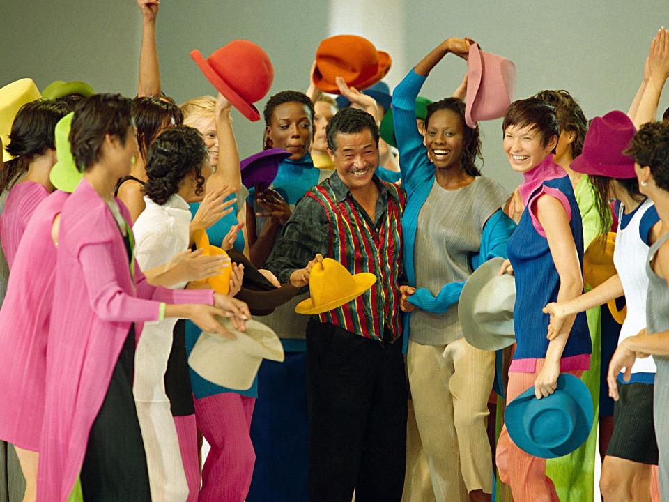 Models in colorful clothes surround Japanese designer Issey Miyake after the presentation of his 1994 Spring-Summer ready-to-wear collection presented in Paris, Oct. 8, 1993.