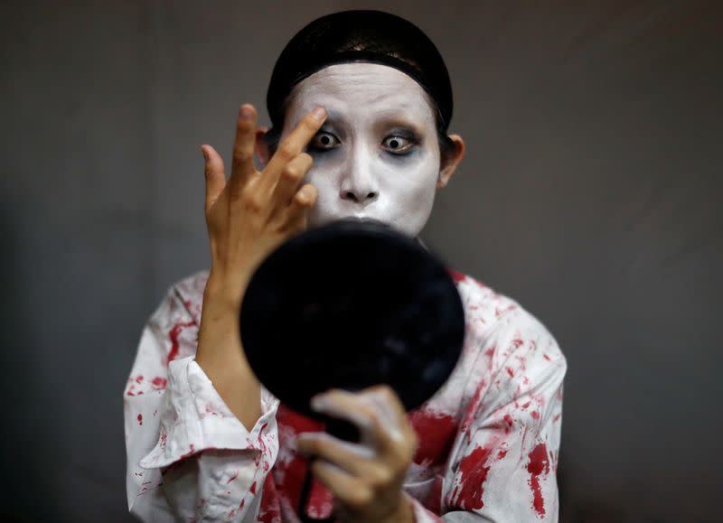 Actor Ayaka Imaide prepares a zombie makeup before her performance at a drive-in haunted house show by Kowagarasetai, for people inside a car in order to maintain social distancing amid the spread of the coronavirus disease (COVID-19), in