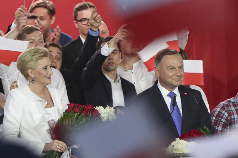 Incumbent President Andrzej Duda, right, smiles next to his wife Agata Kornhauser-Duda while addressing supporters in Pultusk, Poland, Sunday, July 12, 2020. Conservative Duda ran against liberal Warsaw Mayor Rafal Trzaskowski in a razor-blade-close presidential election runoff and exit poll shows election is too close to call. (AP Photo/Czarek Sokolowski)