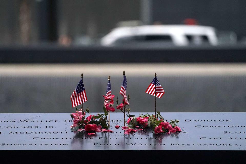 <p>BRYAN R. SMITH/AFP via Getty Images</p> American flags and flowers line the memorial pool at the National September 11 Memorial on Sept. 11, 2023 in New York