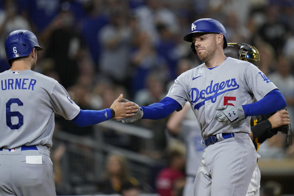 Los Angeles Dodgers' Freddie Freeman, right, is greeted by teammate Trea Turner after hitting a two-run home run during the seventh inning of a baseball game against the San Diego Padres, Saturday, Sept. 10, 2022, in San Diego. (AP Photo/Gregory Bull)