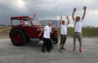 Swiss fans Josef Wyer, Beat Studer and Werner Zimmermann celebrate after driving an old-time tractor from home to Kaliningrad stadium to watch their team playing against Serbia, in Kaliningrad, Russia June 21, 2018. REUTERS/Mariana Bazo
