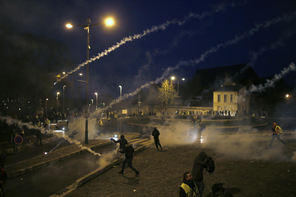 Police fires tear gas grenades during a demonstration in Bourges, central France, Saturday, Jan. 12, 2019. The French Interior Ministry says about 32,000 people have turned out in yellow vest demonstrations across France, including 8,000 in Paris, where scuffles broke out between protesters and police. (AP Photo/Rafael Yaghobzadeh)