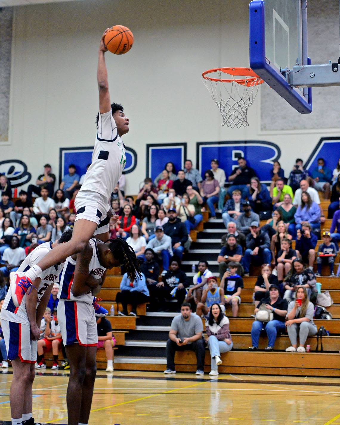 St. Marys Cayden Ward jumps over Modesto Christians Drevon Johnson and Armon Naweed during the Slam Dunk Contest during the 27th Annual Six County All Star Senior Basketball Classic Boys game at Modesto Junior College in Modesto California on April 27, 2024. Ward won the Slam Dunk Contest. John Westberg