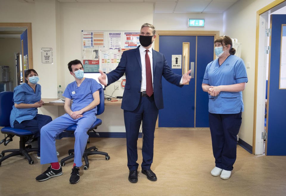 Britain's Labour Party leader Keir Starmer, center, meets staff in the Clinical Research Facility, a joint facility with NHS Lothian, at the University of Edinburgh School of Medicine, Edinburgh, Scotland, Thursday Sept. 17, 2020. (Jane Barlow/PA via AP)