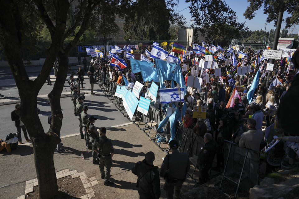 Protesters wave flags and hold banners against Benjamin Netanyahu's new government in front of Israel's Parliament in Jerusalem, Thursday, Dec. 29, 2022. Netanyahu was set to return to office Thursday at the helm of the most religious and ultranationalist government in Israel's history, vowing to implement policies that could cause domestic and regional turmoil and alienate the country's closest allies. (AP Photo/Oded Balilty)