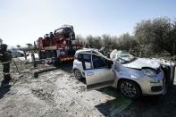 Italian Firefighters work near the wreckage of a car which was hit by a tree fallen due to strong winds and had caused the death of the driver in Guidonia, Italy, Saturday, Feb. 23, 2019. (Giuseppe Lami/ANSA Via AP)