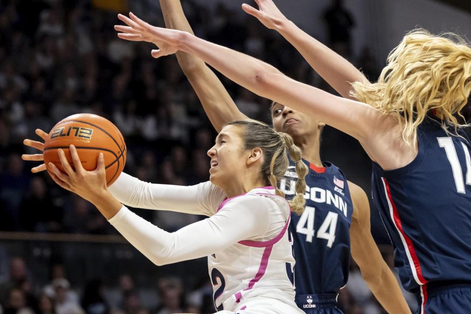 Villanova guard Bella Runyan, left, moves past UConn forwards Aubrey Griffin (44) and Dorka Juhasz, right, during the second half of an NCAA college basketball game, Saturday, Feb. 18, 2023, in Villanova, Pa. (AP Photo/Laurence Kesterson)