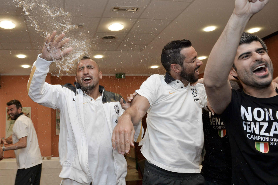 Juventus' Arturo Vidal, left, and Fabio Quagliarella celebrate after winning the Serie A overall soccer title, in a Turin hotel, Italy, Sunday, May 4, 2014. Juventus clinched its third straight and 30th overall Serie A title Sunday without even playing. With second-place Roma losing 4-1 at Catania, Juventus' eight-point lead became insurmountable because Roma only has two matches remaining. Juventus, which has three games to play, can celebrate when it hosts Atalanta on Monday although the Turin squad's players and coach Antonio Conte were already celebrating outside their team hotel wearing championship T-shirts. (AP Photo/Daniele Badolato, Lapresse)