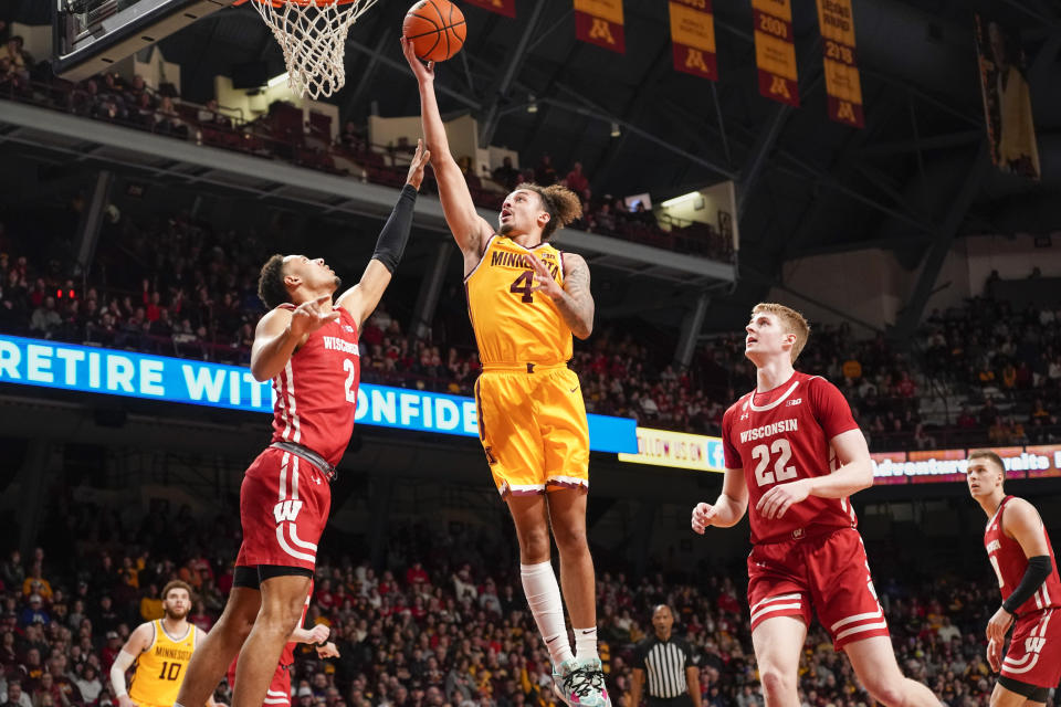 Minnesota guard Braeden Carrington (4) goes up for a shot between Wisconsin guard Jordan Davis (2) and forward Steven Crowl (22) during the first half of an NCAA college basketball game on Sunday March 5, 2023, in Minneapolis. (AP Photo/Craig Lassig)