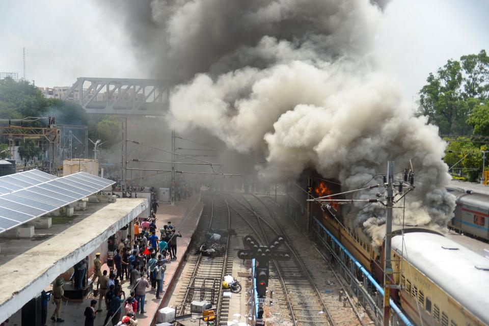 Protesters set a train on fire during a demonstration against the government's new 