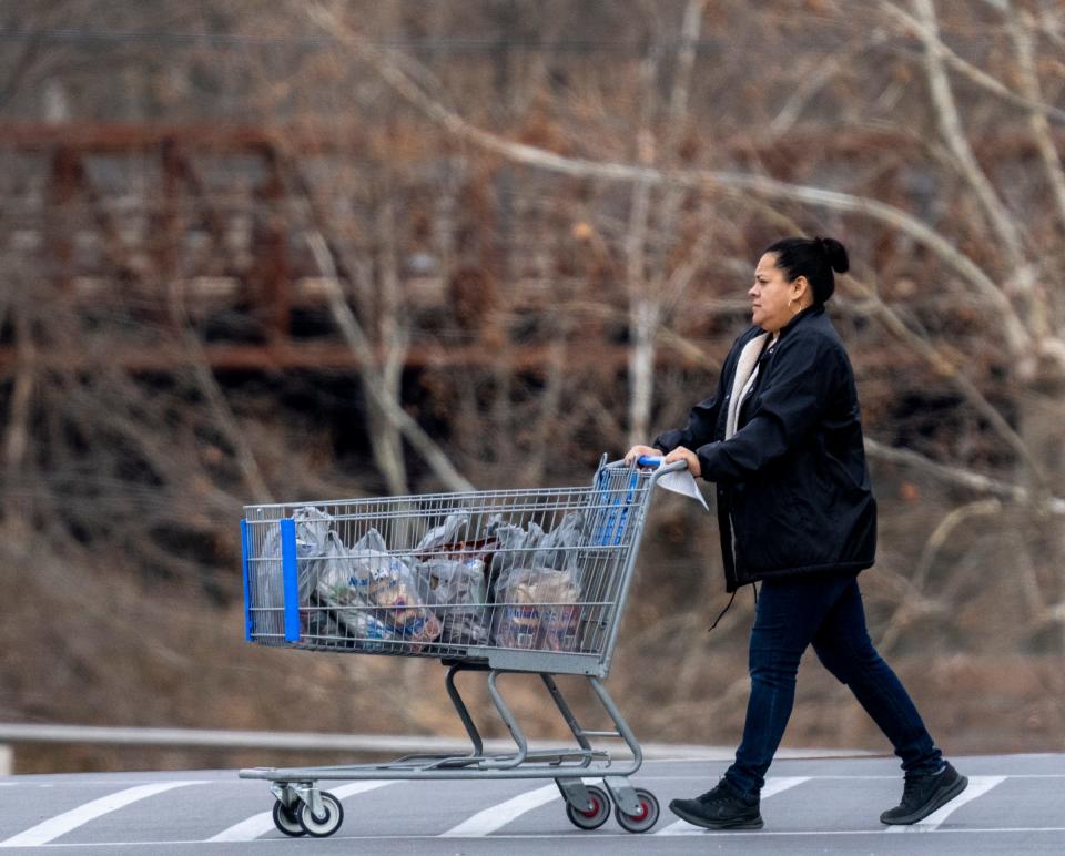 A shopper takes a basket of store-provided plastic bags away from the Walmart Neighborhood Market in the Fall Creek Manor neighborhood on Tuesday, Dec. 13, 2022. On a recent IndyStar survey, 100 percent of the customers at this store used single-use plastic bags. 