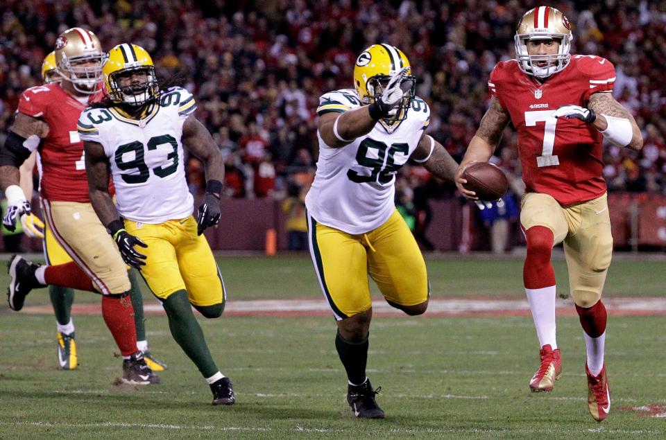 San Francisco 49ers quarterback Colin Kaepernick out runs Green Bay Packers Mike Neal (96) while running for a touchdown during the first quarter of  their divisional playoff game Saturday, January 12, 2013 at Candlestick Park in San Francisco, Calif.